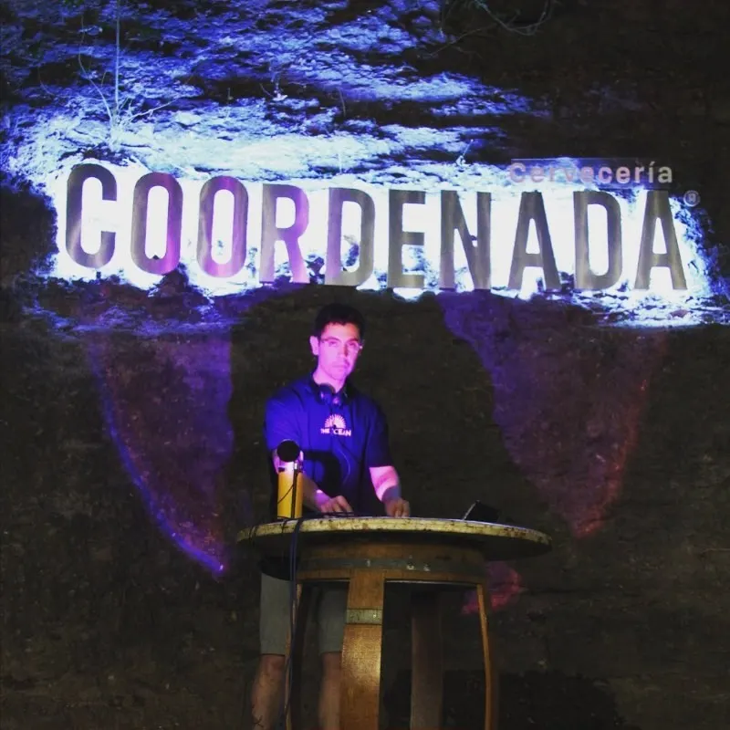 Músico en el escenario bajo el letrero de Coordenada